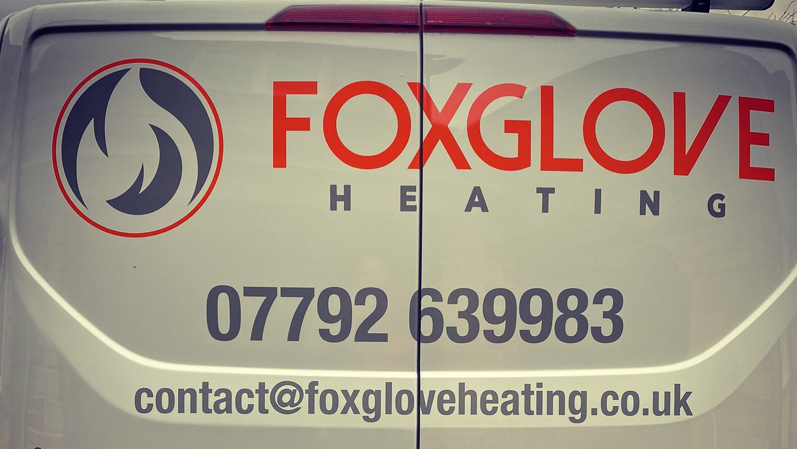The back of the Foxglove Heating van with the logo, phone number and email address