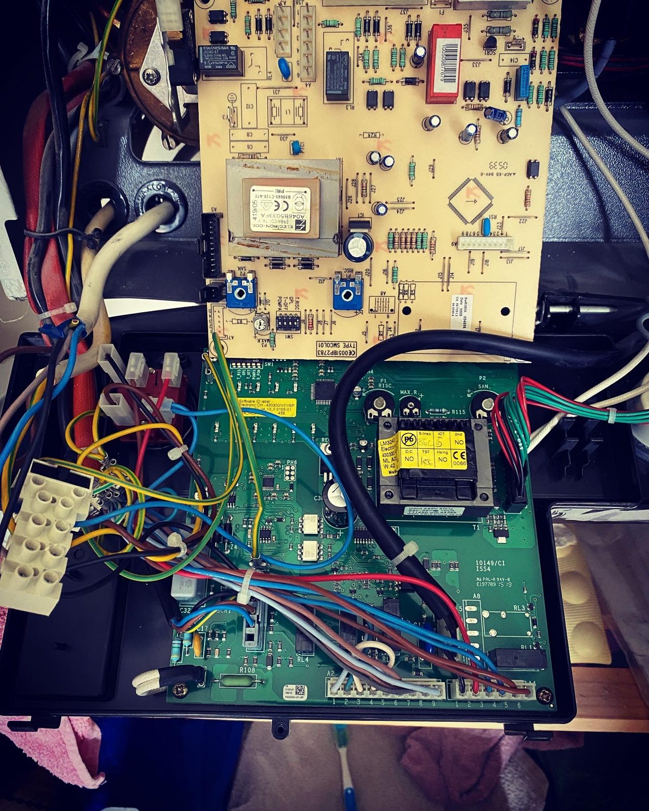 A boiler control board and wiring opened up for fault finding