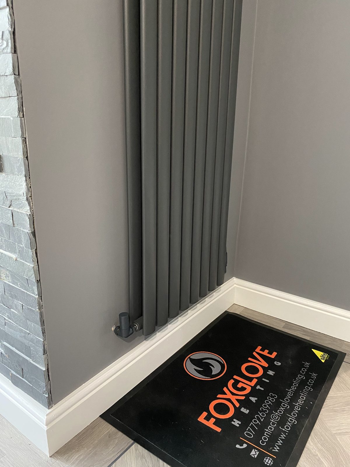 A new anthracite vertical radiator with a Foxglove Heating mat on the floor